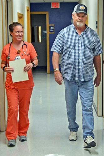 一个肺部康复病人和他们的护士走过医院的大厅